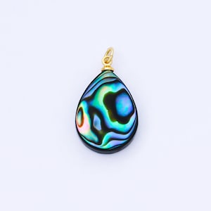 May include: A teardrop-shaped pendant with iridescent abalone shell inlay. The shell displays a swirling pattern of blues, greens, and hints of pink and gold. A small gold-colored bail is attached at the top for a necklace chain.