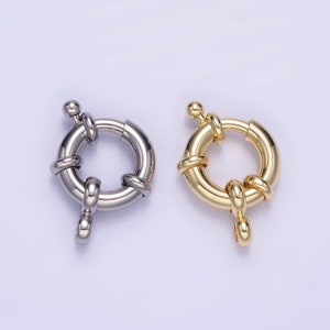 May include: Two round jewelry clasps, one silver-toned and one gold-toned. Each clasp features a circular design with a spring-loaded mechanism and a small loop for attachment. The clasps are designed for jewelry making.