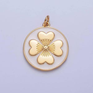 May include: Gold-tone pendant charm featuring a four-leaf clover design with a white enamel background.