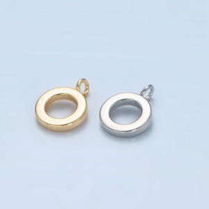 May include: Two metal circle pendant charms, one gold and one silver, with a small loop at the top for attaching to a necklace or bracelet.