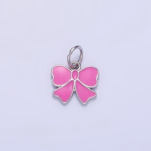 May include: A pink enamel bow charm with a silver metal ring. The charm is a cute and decorative accessory for jewelry making or crafts.