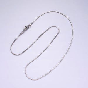 Puede incluir: Un collar de cadena de serpiente plateado con cierre de langosta.