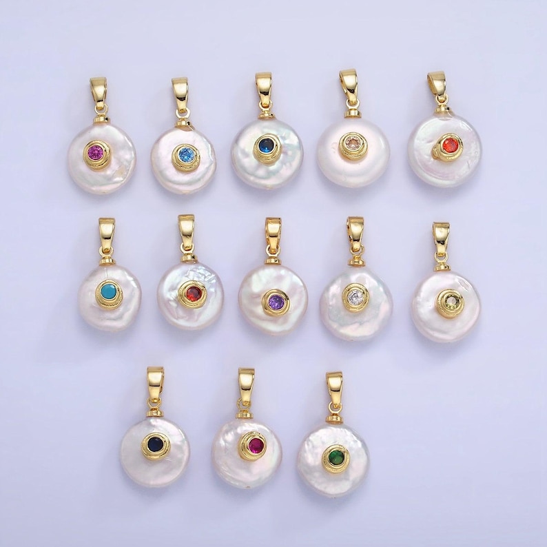 May include: A set of 12 gold-tone pendants with white pearl-like round charms. Each charm has a small, colorful gemstone in the center.