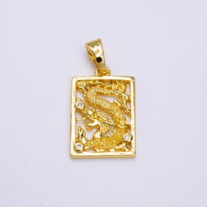 May include: Gold-colored pendant with a rectangular frame and a detailed dragon design. The dragon is textured and has small, clear accent stones. The pendant has a loop for a chain.
