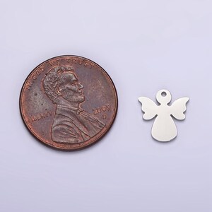 May include: A silver angel charm pendant, approximately the size of a US penny.