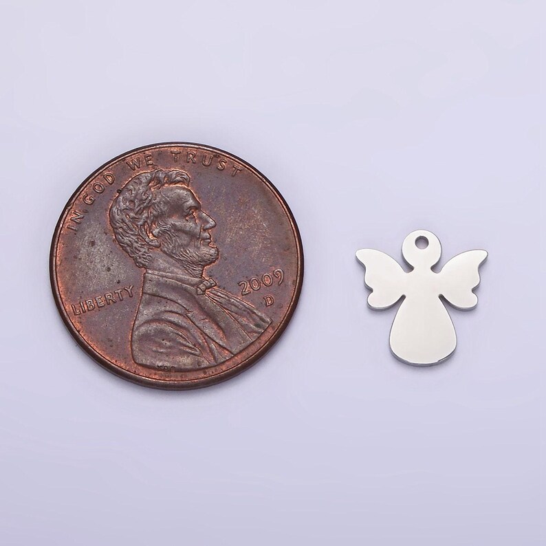 May include: A silver angel charm pendant, approximately the size of a US penny.