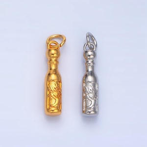 May include: Two small bottle-shaped charms, one gold and one silver, with intricate designs. The charms have a loop at the top for attaching to a necklace or bracelet.