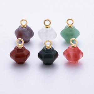 May include: Six gemstone charms in various colors: purple, white, green, red, dark green, and pink. Each charm has a gold-colored loop at the top for attaching to jewelry. The charms have a faceted, geometric shape.