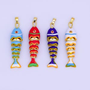Può includere: Quattro ciondoli colorati a forma di pesce con dettagli dorati. Ogni ciondolo presenta una diversa combinazione di colori: blu, rosso, viola e bianco. I ciondoli hanno un anello dorato nella parte superiore per essere appesi.