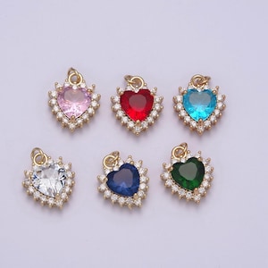 Puede incluir: Seis colgantes de corazón de oro con piedras preciosas de diferentes colores. Cada colgante está rodeado por un halo de piedras pequeñas transparentes.
