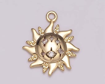 May include: A gold-toned sun charm with clear rhinestones. The sun has a textured surface and a loop at the top for attaching to a necklace or bracelet.