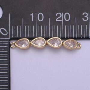 Puede incluir: Un conector dorado con tres cristales transparentes en forma de l&aacute;grima. El conector mide aproximadamente 2 cm de largo.