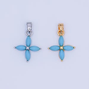 Op de afbeelding: Twee hangerkettingen, één zilverkleurig en één goudkleurig, elk met een turquoise bloemmotief met vier bloembladen. De hangers hebben een oogje om aan een ketting te bevestigen.