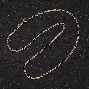 May include: A gold chain necklace with a lobster clasp closure. The chain is made of small, oval-shaped links.