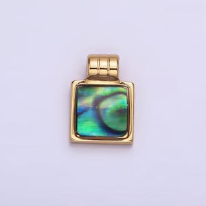 Puede incluir: Un colgante de oro con una incrustación cuadrada de concha de abulón. La concha tiene un patrón verde, azul e iridiscente.