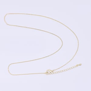 May include: A delicate gold-colored necklace with a fine chain. The necklace features a lobster clasp and an adjustable chain for a customizable fit. The jewelry is displayed against a plain white background.