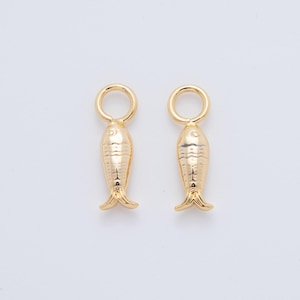 Op de afbeelding: Twee goudkleurige visvormige bedels met een getextureerd oppervlak en een kleine lus aan de bovenkant. De bedels hebben een gedetailleerd vin- en staartontwerp, perfect voor het maken van sieraden of knutselprojecten.