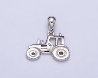 May include: A silver tractor pendant with intricate detailing, including wheels, a cab, and exhaust pipes. The pendant has a loop at the top for attaching to a chain or bracelet. The tractor is a miniature replica.