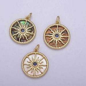 May include: Three gold sun pendant charms with blue gemstone centers. The sun designs are set in different shell materials: abalone, tiger eye, and white mother of pearl.