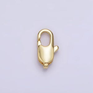 May include: Gold-toned metal lobster clasp for jewelry making. The clasp is a simple, oval-shaped design with a spring-loaded mechanism.