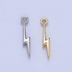 May include: Two lightning bolt charms, one silver and one gold, with a jump ring at the top for attaching to jewellery.