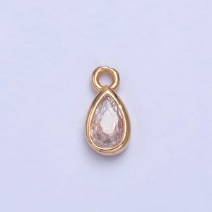 May include: A gold-tone pendant with a clear teardrop-shaped crystal.