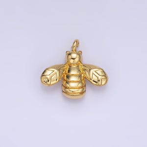 May include: A gold-colored bee charm with detailed wings and a textured body. This charm is perfect for adding a touch of whimsy to jewelry projects.