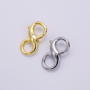 May include: Two metal lobster clasps, one gold and one silver, in the shape of a figure eight.