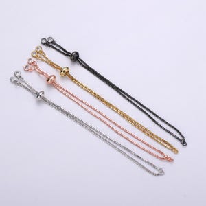 May include: Four adjustable chain bracelets with a sliding bead closure. The bracelets are available in black, gold, rose gold, and silver.