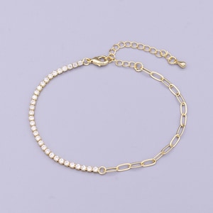 May include: Gold-toned bracelet featuring a row of small, clear crystals on one half and a delicate chain link design on the other. The bracelet has an adjustable chain for a comfortable fit and a secure clasp.