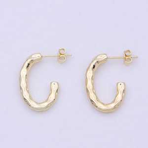 May include: A pair of gold hoop earrings with a textured, hammered finish. The earrings are simple and elegant, and would make a great addition to any jewelry collection.