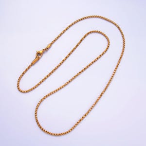 May include: A gold chain necklace with a lobster clasp closure. The chain is made of small, round links.