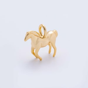 May include: A gold-coloured horse pendant with a loop for attaching to a necklace or bracelet. The horse is depicted in a running pose, with its legs extended. The pendant is made of a shiny, reflective metal.