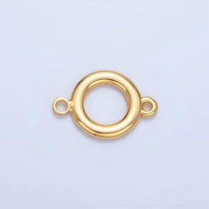 May include: Gold-toned metal connector with two loops. The connector is round with a smooth surface.