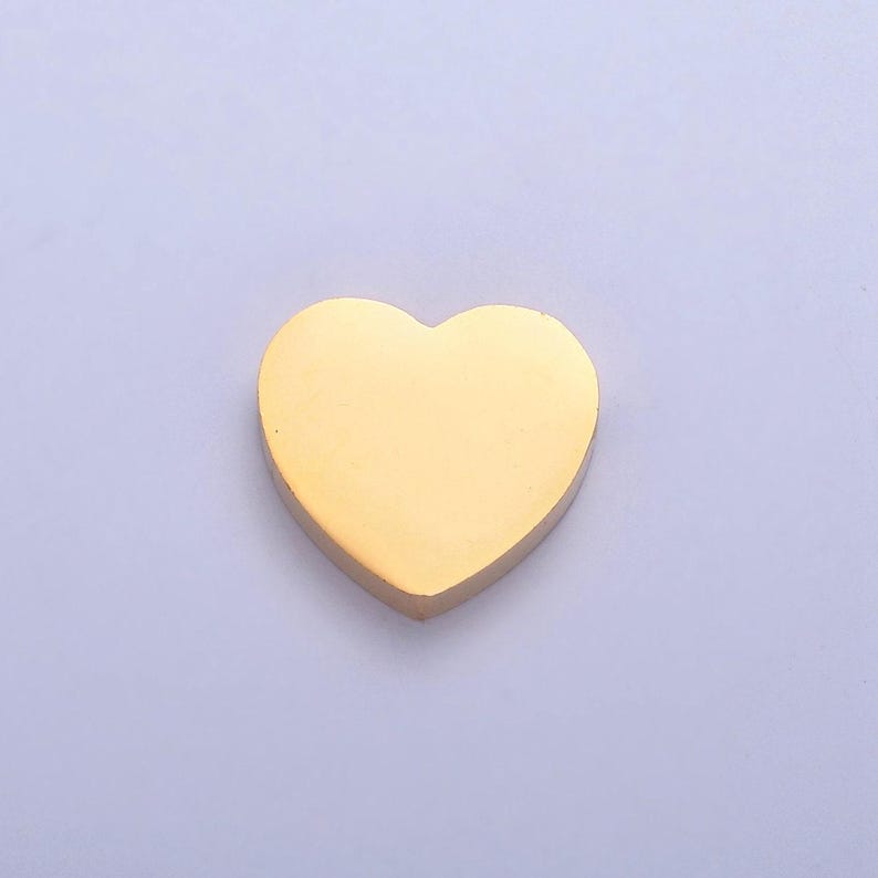 Puede incluir: Un peque&ntilde;o dije en forma de coraz&oacute;n de color dorado.