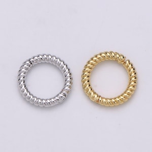 May include: Two twisted metal rings, one silver and one gold. The rings are both about 1 inch in diameter.