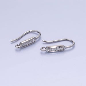 May include: A pair of silver earring hooks with a row of clear cubic zirconia stones on each hook.