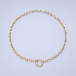 May include: A gold-toned chain necklace featuring a series of uniform oval links connected in a continuous loop. The necklace includes a single circular ring charm positioned at the bottom center, secured with a small lobster claw clasp at the top.