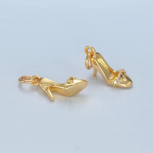 May include: Two gold-tone high heel shoe charms with clear rhinestone accents.