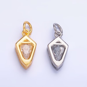 May include: Two diamond-shaped pendants. One is gold-toned with a clear, faceted stone. The other is silver-toned with a gray, faceted stone. Both have a loop at the top for a chain or cord. Jewelry.