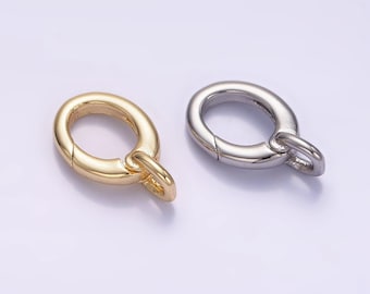 May include: Two metal clasps, one gold and one silver, for attaching jewelry or other items. The clasps are oval-shaped with a small loop on one end.