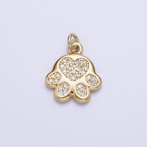 May include: Gold-tone paw print charm with a heart-shaped center, encrusted with clear cubic zirconia stones.