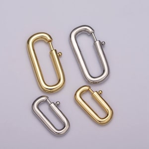 May include: Four oval-shaped metal earring closures in two different finishes: gold and silver. The closures are open on one side and have a small ball on the other side.