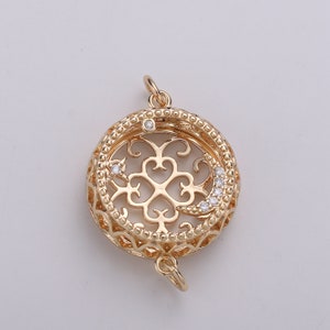 May include: Gold-toned pendant with a filigree design featuring a crescent moon and stars. The pendant has a round shape and is adorned with clear cubic zirconia stones.