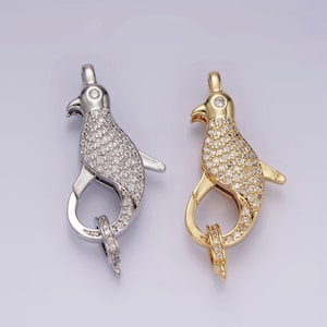 May include: Two silver and gold tone penguin-shaped clasps with clear crystal accents. The clasps are designed to be used as jewelry closures.