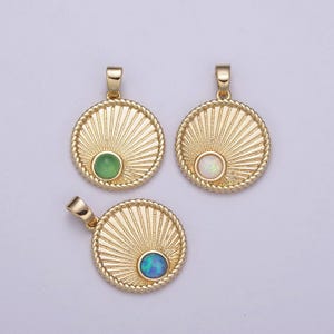 May include: Three gold pendants with a sunburst design and a round gemstone in the center. The gemstones are green, white, and blue.