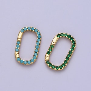 May include: Two gold-toned oval-shaped charms with a clasp closure. One charm is decorated with turquoise blue stones and the other with green stones.
