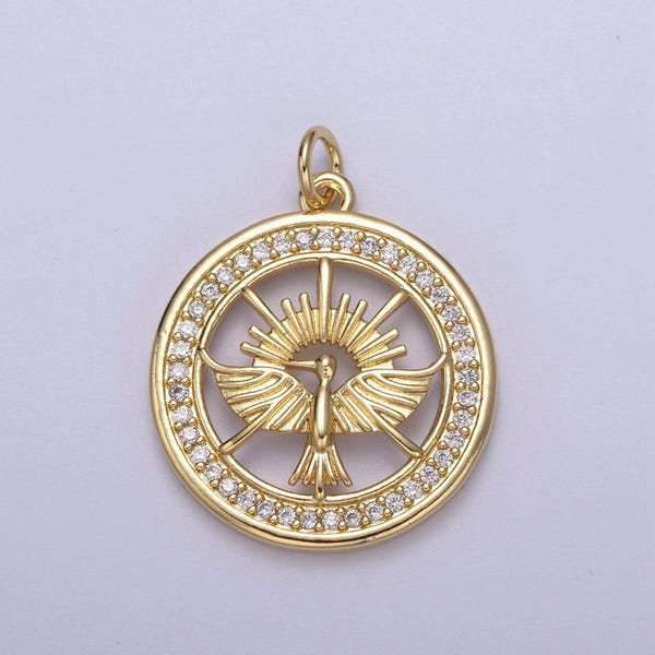 May include: Gold-toned pendant featuring a stylized bird with outstretched wings inside a circle of clear sparkling stones.