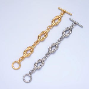 May include: Two gold and silver bracelets with a knot design. The bracelets have a toggle clasp.