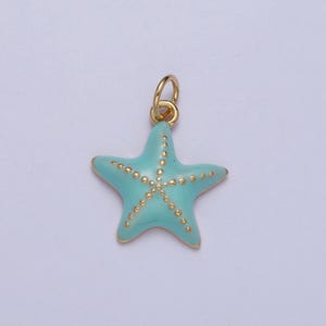 May include: A gold-colored starfish charm with a light blue enamel finish. The starfish has gold-colored dots and a gold-colored loop for attaching to a necklace or bracelet. The charm is a jewelry component.